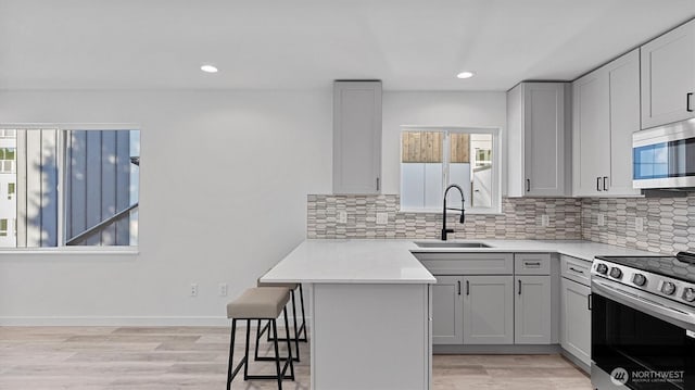 911 Hiawatha Pl S, Seattle, WA 98144 - kitchen with a sink, stainless steel appliances, healthy amount of natural light, a breakfast bar area, and recessed lighting