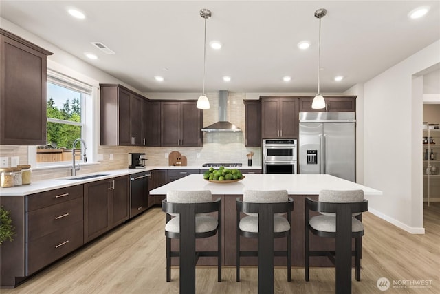 13436 NE 105th Ct Unit 17, Kirkland, WA 98033 - kitchen with stainless steel appliances, wall chimney exhaust hood, a sink, dark brown cabinets, and recessed lighting