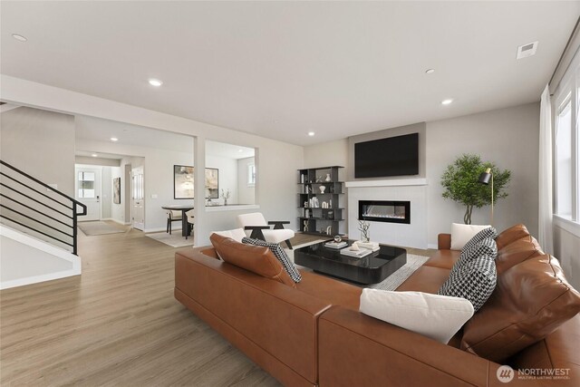 13436 NE 105th Ct Unit 17, Kirkland, WA 98033 - living room featuring a glass covered fireplace, light wood-style flooring, stairway, recessed lighting, and baseboards