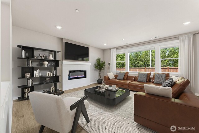 13436 NE 105th Ct Unit 17, Kirkland, WA 98033 - living area with wood finished floors, a glass covered fireplace, recessed lighting, and baseboards