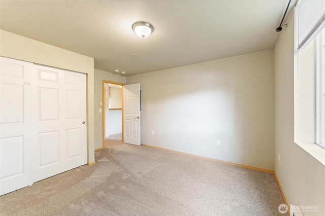 10109 186th St E Unit 249, Puyallup, WA 98371 - unfurnished bedroom with carpet, baseboards, a closet, and a baseboard heating unit
