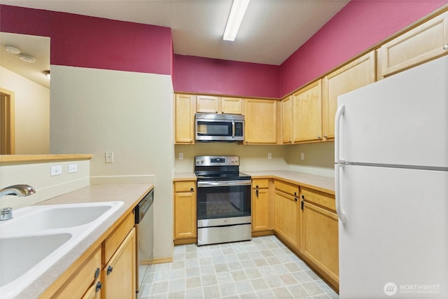 10109 186th St E Unit 249, Puyallup, WA 98371 - kitchen featuring appliances with stainless steel finishes, a sink, light countertops, and light brown cabinetry