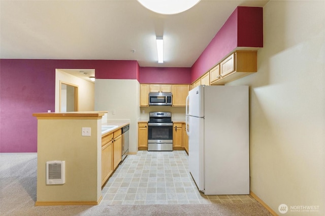 10109 186th St E Unit 249, Puyallup, WA 98371 - kitchen with stainless steel appliances, a peninsula, light countertops, light brown cabinets, and baseboards