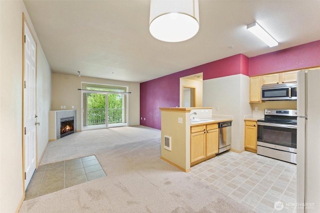 10109 186th St E Unit 249, Puyallup, WA 98371 - kitchen featuring stainless steel appliances, light carpet, light brown cabinets, open floor plan, and a peninsula
