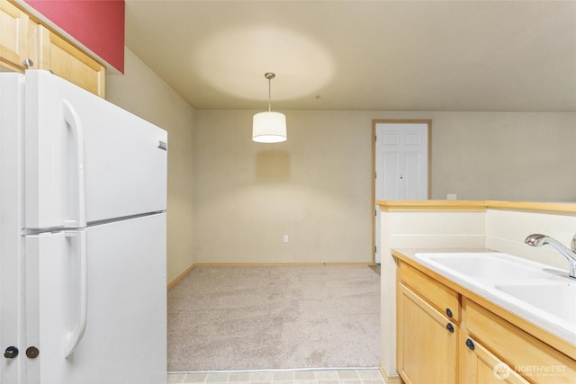 10109 186th St E Unit 249, Puyallup, WA 98371 - kitchen with freestanding refrigerator, light brown cabinets, light colored carpet, a sink, and hanging light fixtures