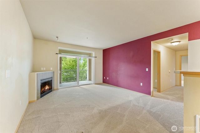 10109 186th St E Unit 249, Puyallup, WA 98371 - unfurnished living room featuring carpet, a tiled fireplace, and baseboards