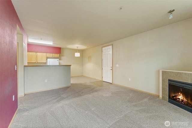 10109 186th St E Unit 249, Puyallup, WA 98371 - unfurnished living room with carpet flooring, a tiled fireplace, and baseboards