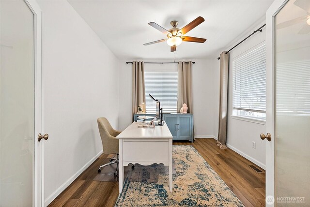 home office featuring ceiling fan, baseboards, and dark wood finished floors