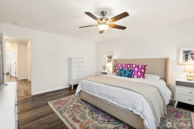 bedroom with dark wood-type flooring, a ceiling fan, and baseboards