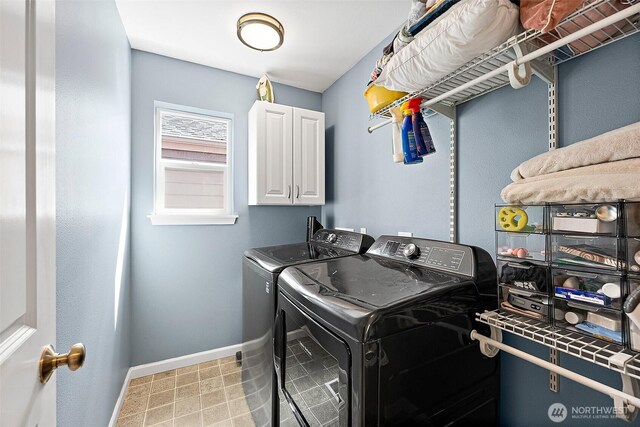 laundry area featuring washing machine and clothes dryer, cabinet space, and baseboards