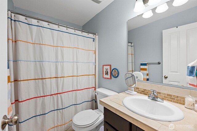 bathroom featuring tasteful backsplash, toilet, vanity, and a shower with curtain