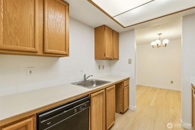 kitchen with dishwashing machine, a sink, a chandelier, light wood finished floors, and light countertops