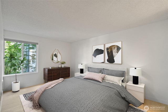 bedroom featuring wood finished floors and a textured ceiling