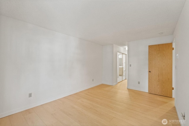 spare room with light wood-type flooring and baseboards
