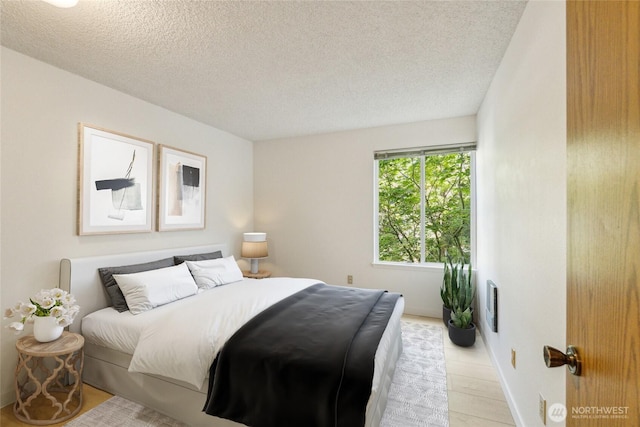 bedroom featuring a textured ceiling and baseboards