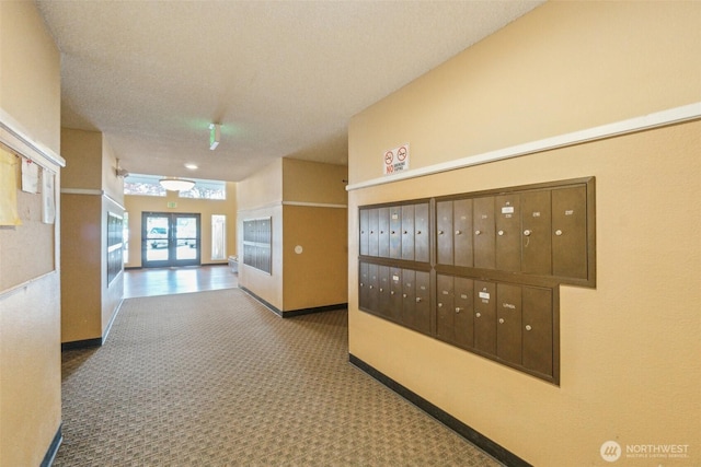 hallway with carpet flooring, mail area, french doors, and baseboards