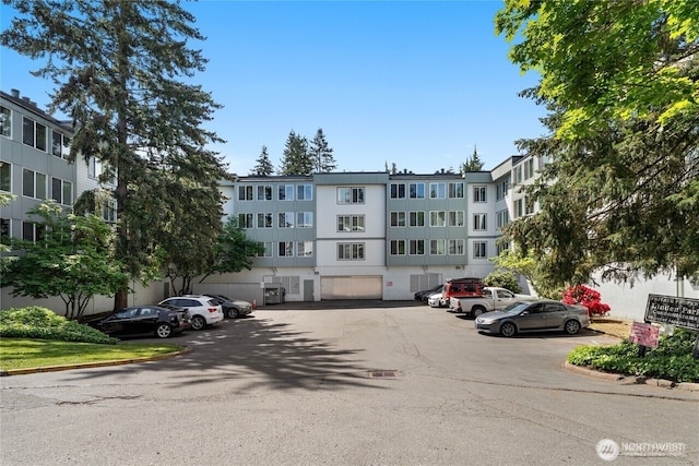 view of apartment building / complex featuring uncovered parking