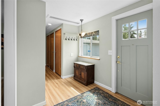 foyer featuring light wood-style floors and baseboards
