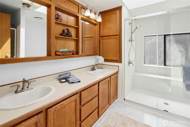 full bath with a stall shower, marble finish flooring, and double vanity