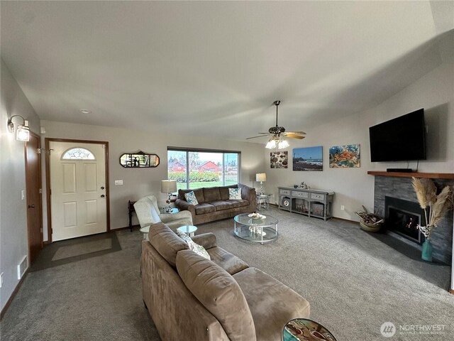 carpeted living area with a fireplace with flush hearth, a ceiling fan, and baseboards