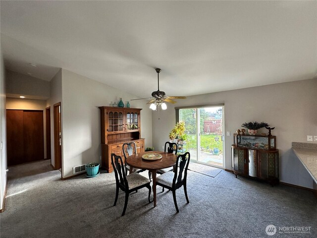 carpeted dining area featuring ceiling fan, vaulted ceiling, and baseboards