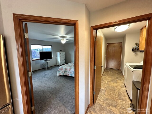corridor featuring washer and clothes dryer and baseboards
