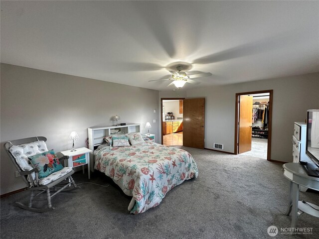 carpeted bedroom with a spacious closet, ceiling fan, and a closet