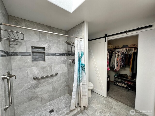 full bathroom featuring a stall shower, toilet, and a spacious closet
