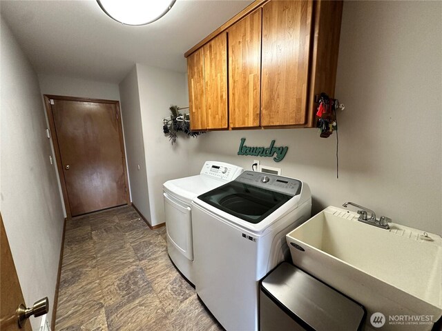 laundry room featuring cabinet space, independent washer and dryer, stone finish flooring, and baseboards