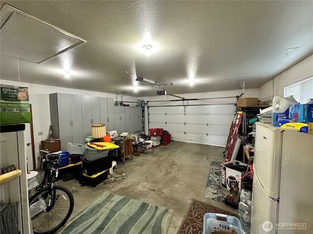 garage featuring freestanding refrigerator and a garage door opener