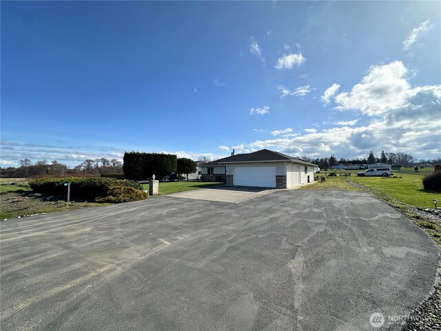 view of front of house with an attached garage, a front lawn, and driveway
