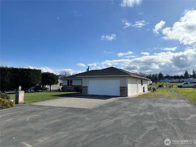 view of side of property featuring a garage, driveway, and a yard