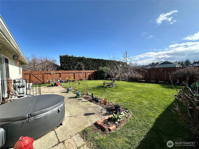 view of yard with a hot tub and a patio area