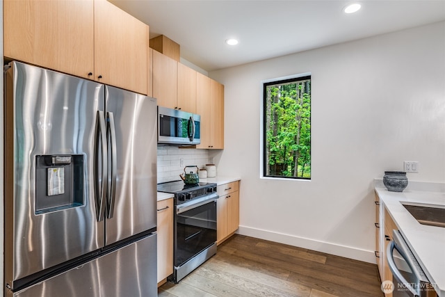 22513 Clearland Ln SE, Yelm, WA 98597 - kitchen featuring appliances with stainless steel finishes, light brown cabinetry, light countertops, wood finished floors, and recessed lighting
