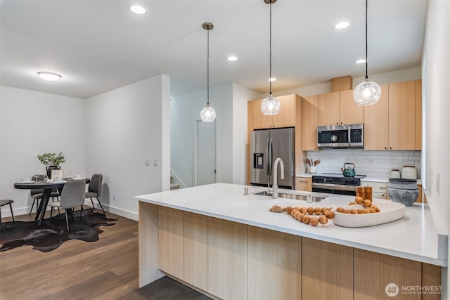 22513 Clearland Ln SE, Yelm, WA 98597 - kitchen with stainless steel appliances, light brown cabinets, a sink, tasteful backsplash, and dark wood-style flooring