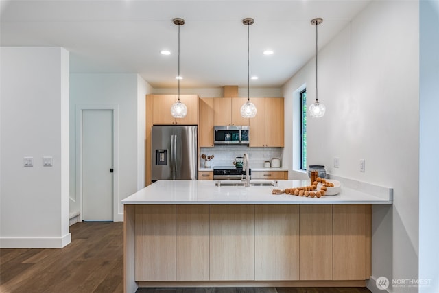 22513 Clearland Ln SE, Yelm, WA 98597 - kitchen with appliances with stainless steel finishes, a peninsula, light brown cabinets, a sink, and decorative backsplash