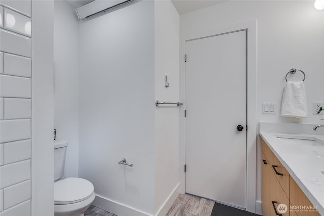 22513 Clearland Ln SE, Yelm, WA 98597 - bathroom with toilet, vanity, wood finished floors, and baseboards