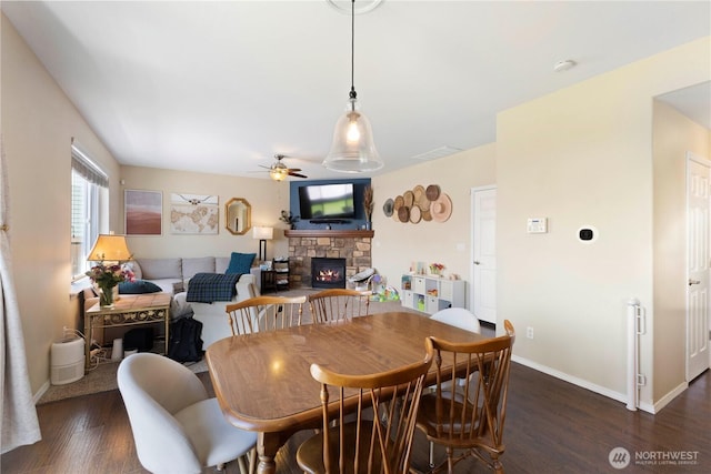 19424 E 26th Avenue Ct E, Spanaway, WA 98387 - dining area with a ceiling fan, a stone fireplace, dark wood finished floors, and baseboards