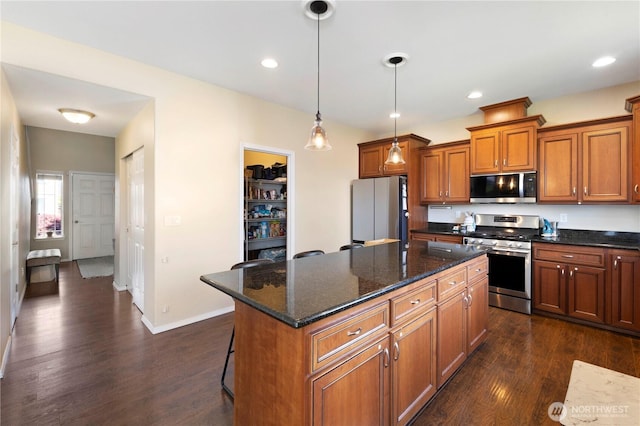 19424 E 26th Avenue Ct E, Spanaway, WA 98387 - kitchen featuring appliances with stainless steel finishes, brown cabinets, dark wood-style flooring, a center island, and recessed lighting