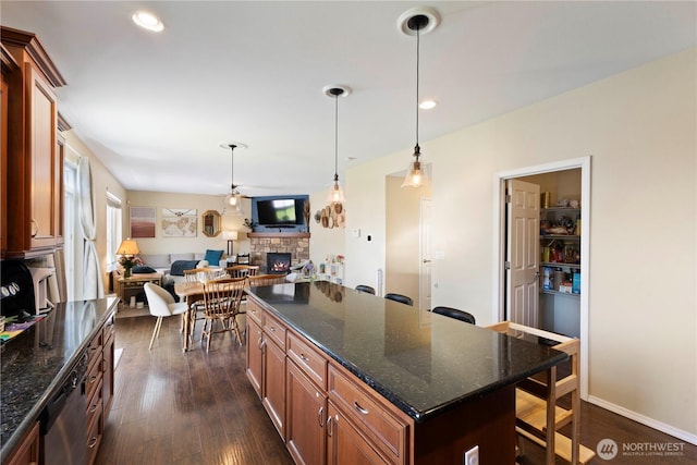 19424 E 26th Avenue Ct E, Spanaway, WA 98387 - kitchen with a stone fireplace, a kitchen breakfast bar, stainless steel dishwasher, dark wood-style flooring, and recessed lighting