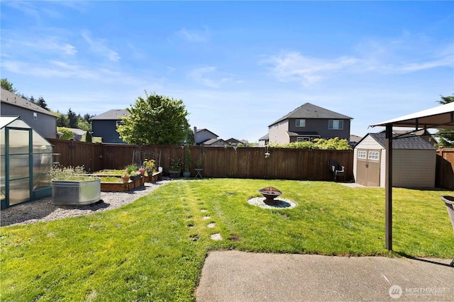 19424 E 26th Avenue Ct E, Spanaway, WA 98387 - view of yard with an outdoor structure, a garden, a greenhouse, an outdoor fire pit, and a storage shed