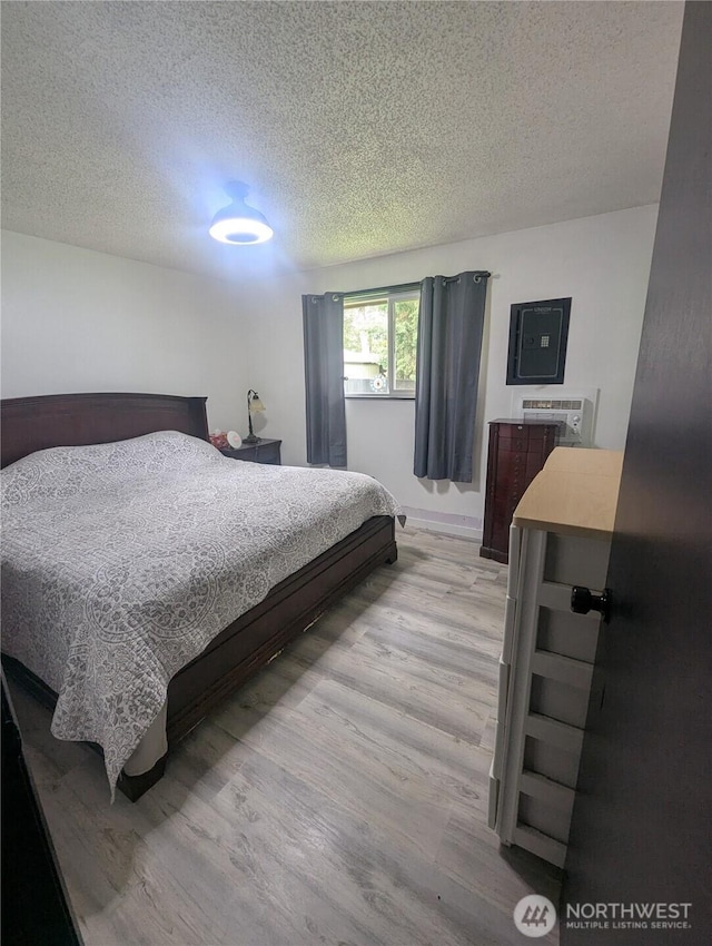 bedroom with a textured ceiling and light wood-style flooring
