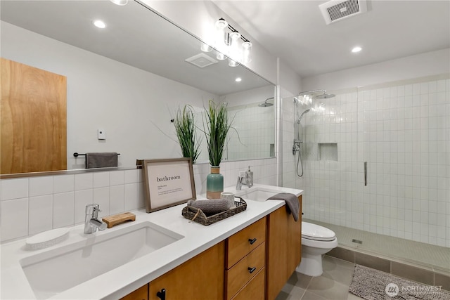 2273 14th Ave W, Seattle, WA 98119 - bathroom featuring tiled shower, double vanity, toilet, recessed lighting, and tile patterned floors