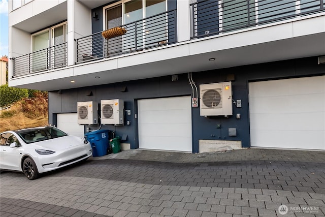 2273 14th Ave W, Seattle, WA 98119 - view of building exterior featuring an attached garage, a cooling unit, and driveway
