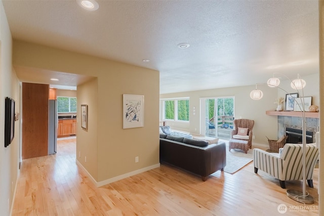 8070 Kispiox Rd, Blaine, WA 98230 - living room featuring light wood-style floors, a tile fireplace, recessed lighting, and baseboards