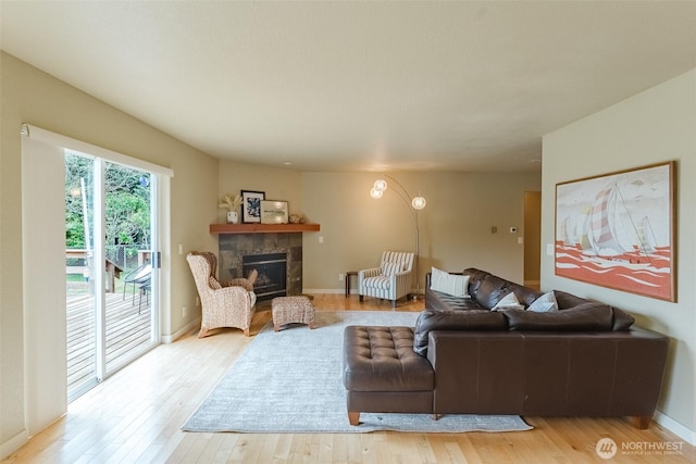 8070 Kispiox Rd, Blaine, WA 98230 - living area with light wood-style flooring, a tile fireplace, and baseboards