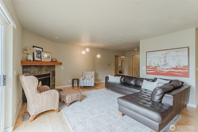 8070 Kispiox Rd, Blaine, WA 98230 - living room featuring light wood-style flooring, a tile fireplace, and baseboards