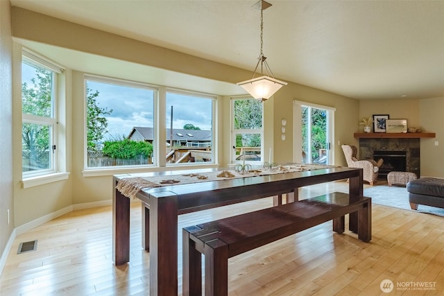 8070 Kispiox Rd, Blaine, WA 98230 - dining area with light wood-style floors, a stone fireplace, and baseboards