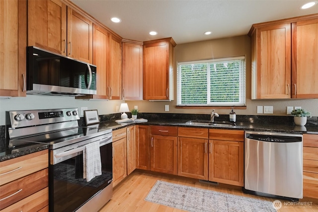 8070 Kispiox Rd, Blaine, WA 98230 - kitchen with stainless steel appliances, a sink, light wood finished floors, dark stone counters, and recessed lighting
