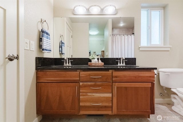 8070 Kispiox Rd, Blaine, WA 98230 - full bath featuring baseboards, toilet, double vanity, tile patterned floors, and curtained shower